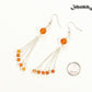 Cascading Carnelian Crystal Drop Earrings beside a dime.