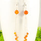 Close up of Cascading Carnelian Crystal Drop Earrings.