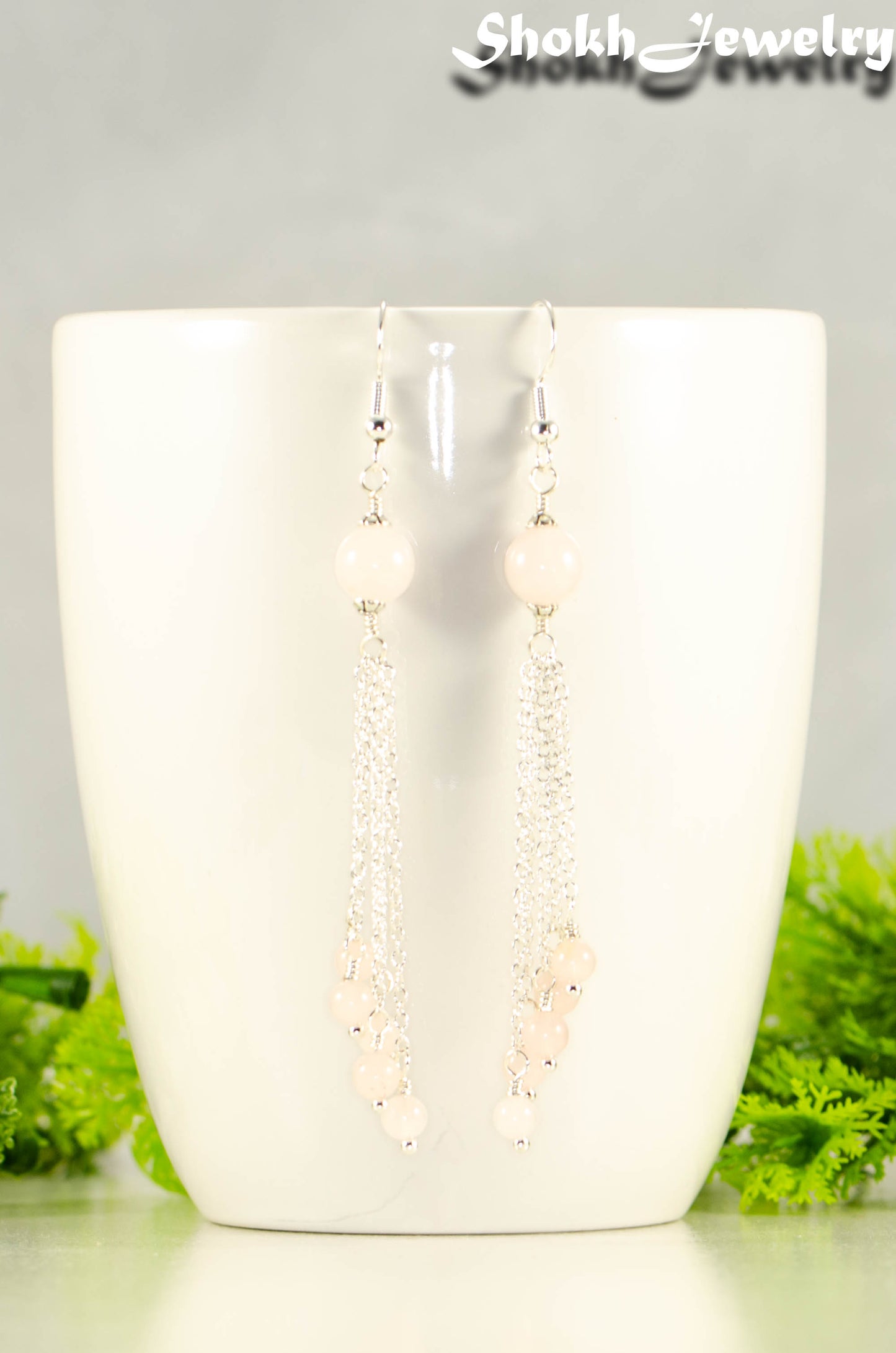 Close up of Cascading Rose Quartz Crystal Drop Earrings.