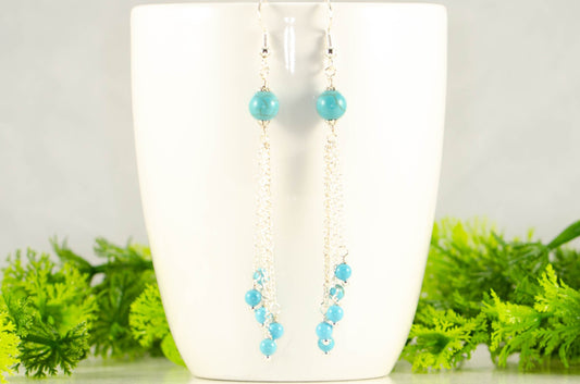 Cascading Turquoise Howlite Gemstone Drop Earrings displayed on a coffee mug.