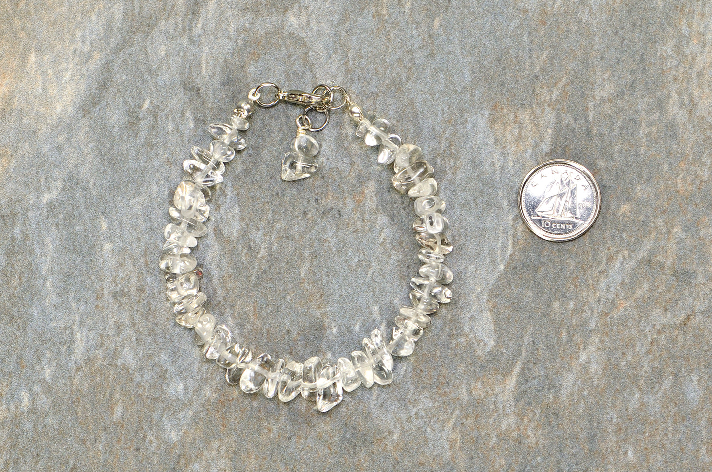 Clear Quartz Crystal Chip Bracelet beside a dime.