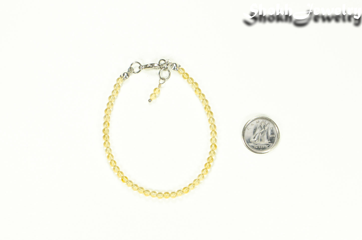 Dainty Citrine anklet beside a dime.