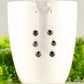 Long Silver Plated Chain and Black Pearl Earrings displayed on a coffee mug.