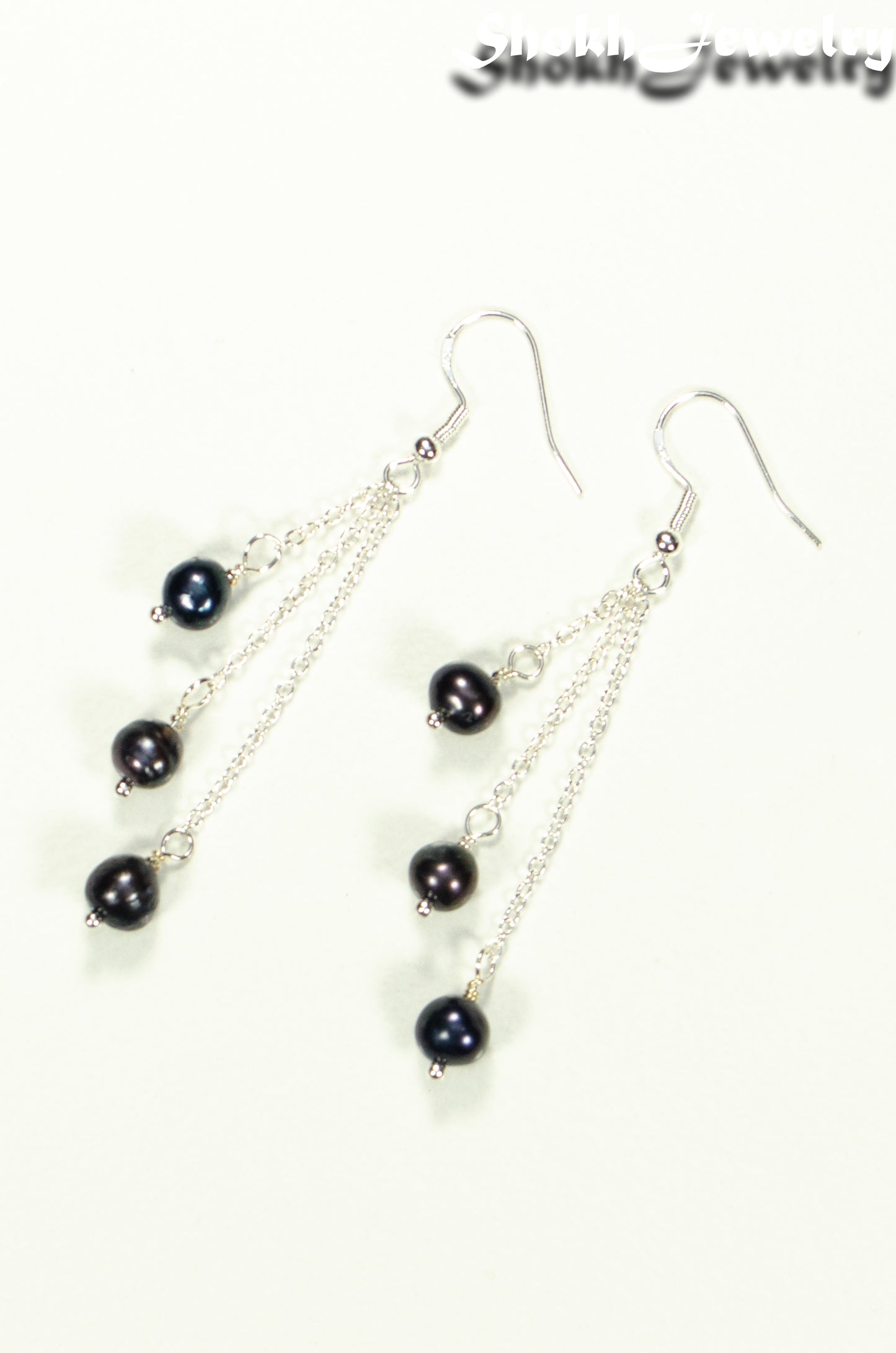 Top view of Long Silver Plated Chain and Black Pearl Earrings.