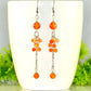 Long Stainless Steel Chain and Carnelian Earrings displayed on a white coffee mug.