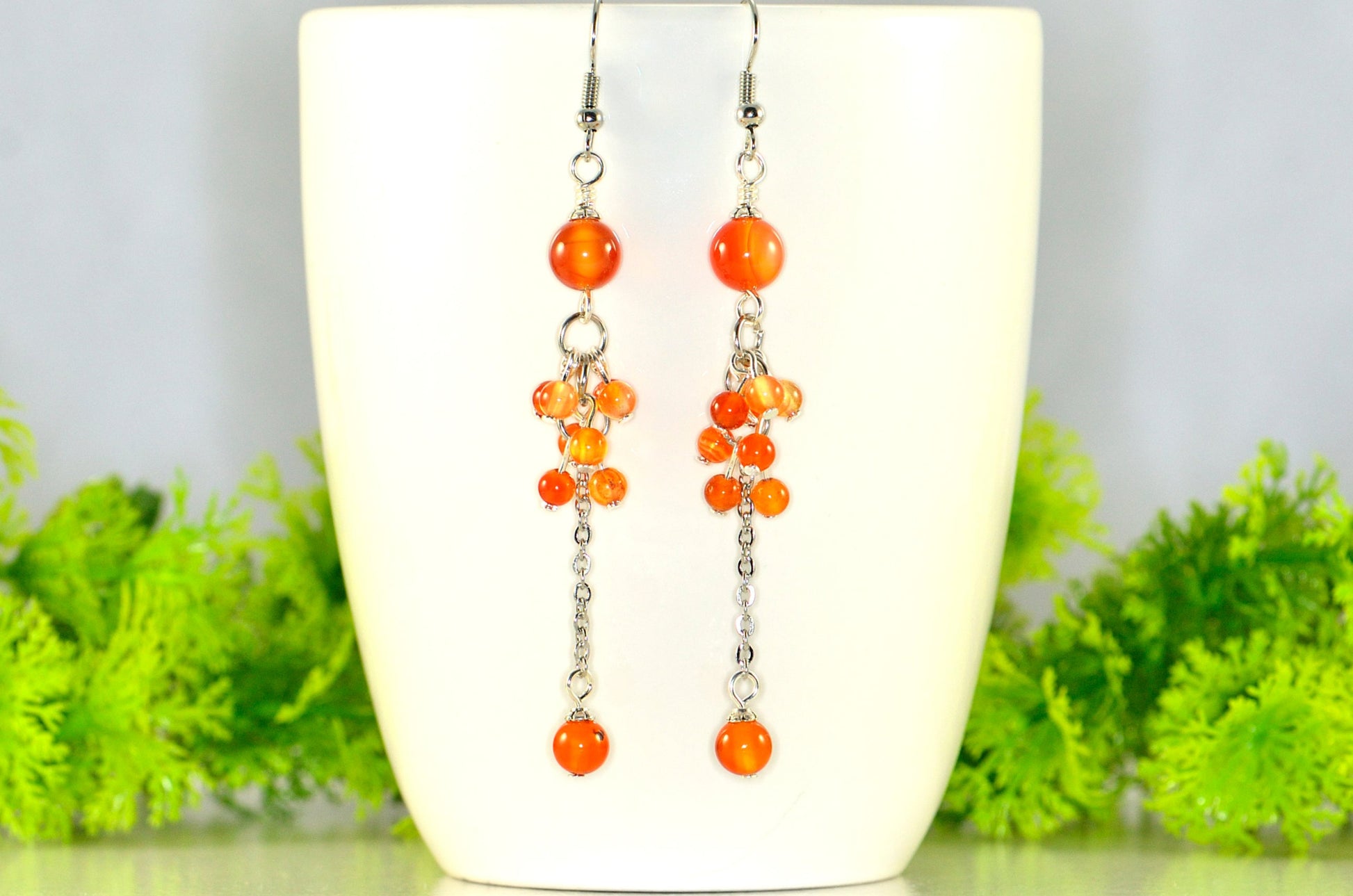 Long Stainless Steel Chain and Carnelian Earrings displayed on a white coffee mug.