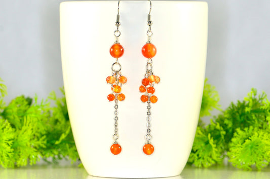 Long Stainless Steel Chain and Carnelian Earrings displayed on a white coffee mug.