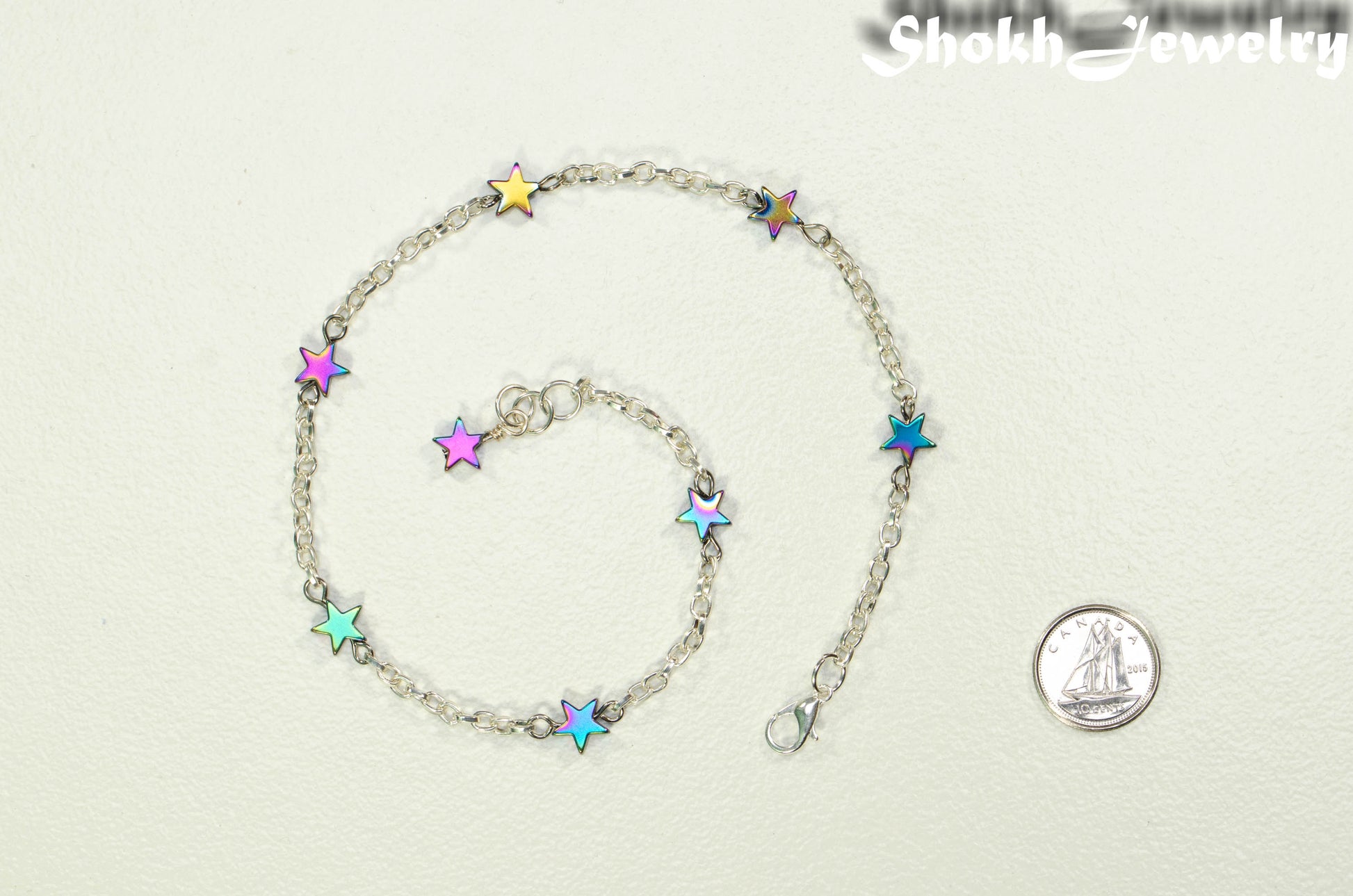Rainbow Hematite Star and Chain Choker Necklace beside a dime.
