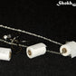 Close up of Miniature Toilet Paper Roll Necklace and Earrings Set.