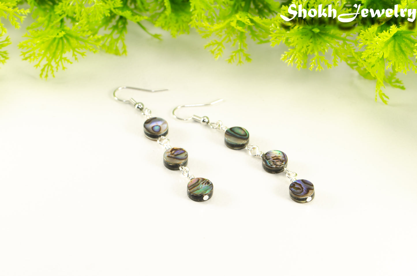 Close up of Elegant Long Natural Abalone Shell Earrings.