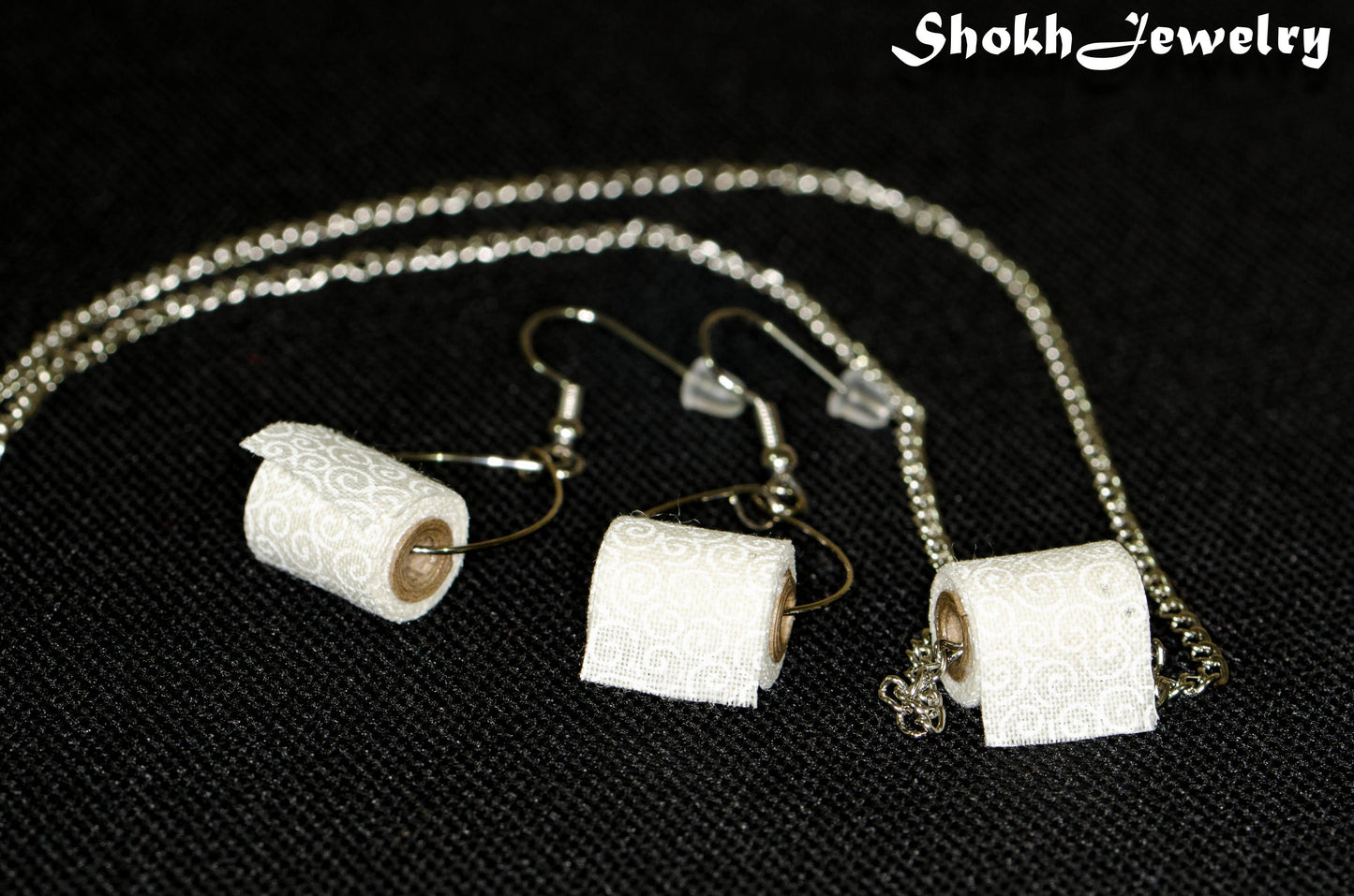 Close up of Tiny Toilet Paper Roll Necklace and Earrings Set.