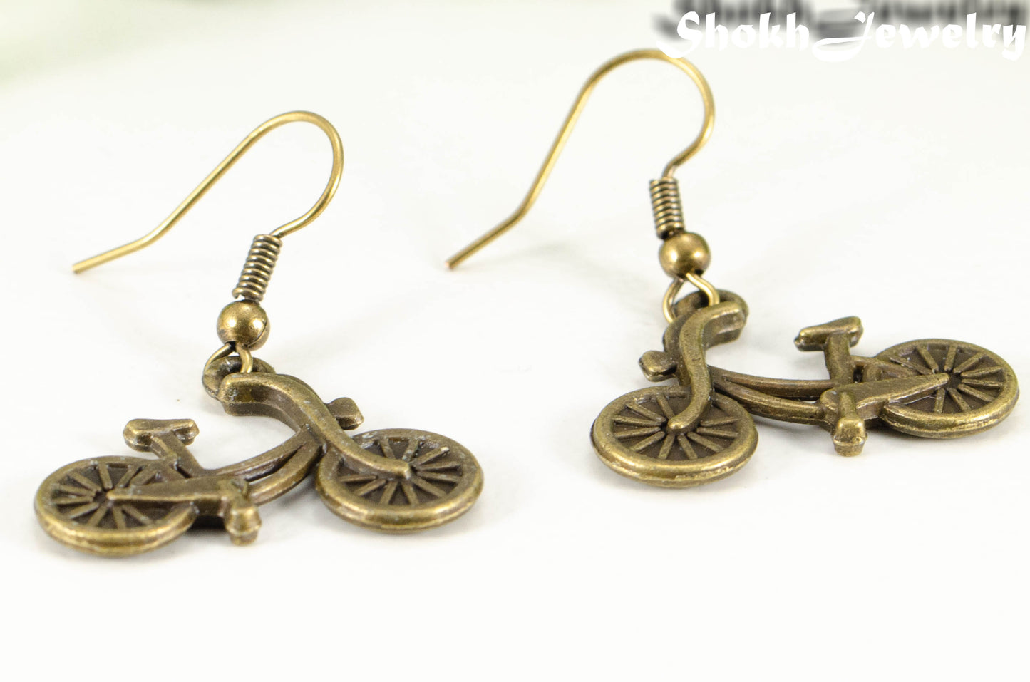 Close up of Antique Bronze Bicycle Charm Earrings.