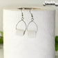 Tiny Toilet Paper Roll Earrings displayed on a toilet paper roll.