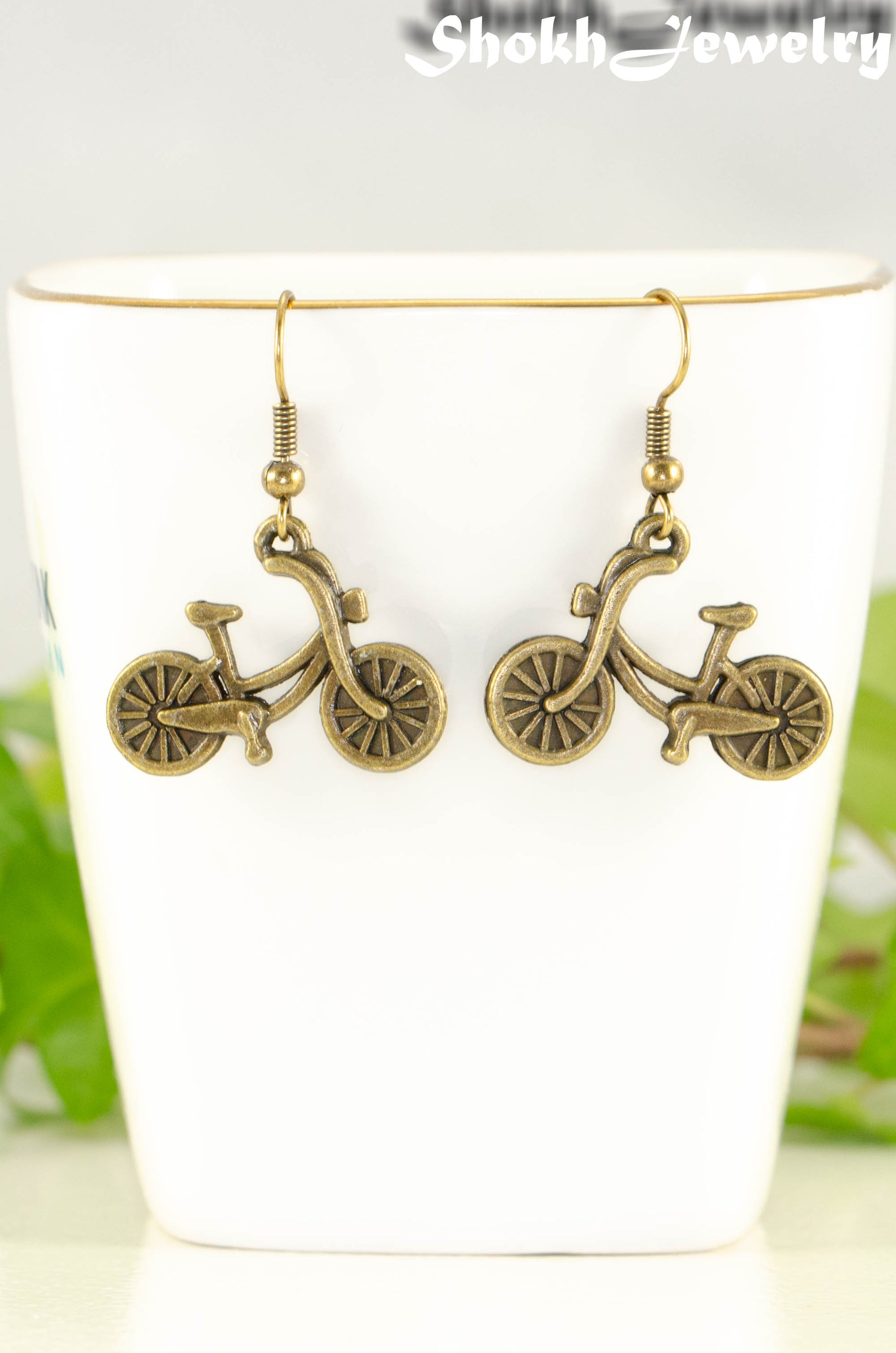 Close up of Antique Bronze Bicycle Charm Earrings.