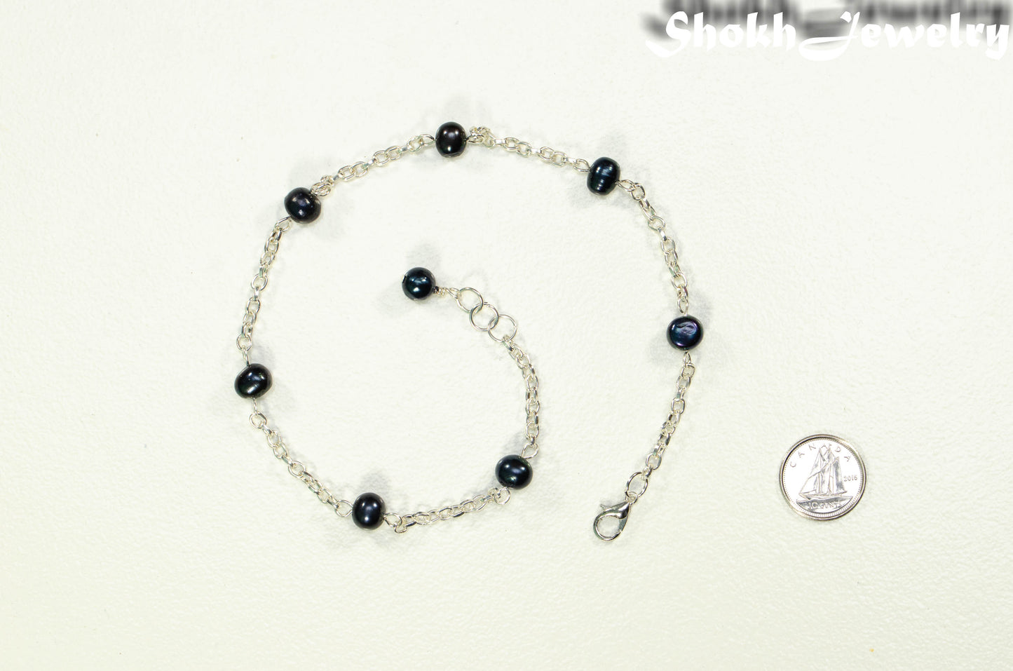 Black Freshwater Pearl and Chain Anklet beside a dime.