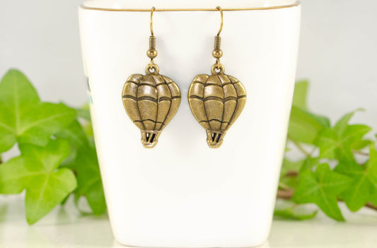 Antique Bronze Hot Air Balloon Charm Earrings displayed on a tea cup.