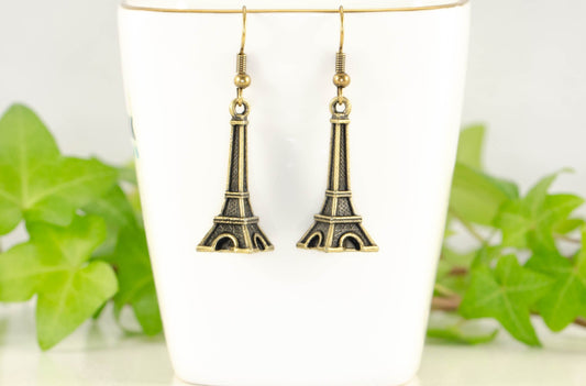 Antique Bronze 3D Eiffel Tower Charm Earrings displayed on a tea cup.