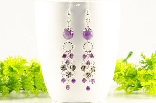 Statement Amethyst and Heart Chandelier Earrings displayed on a coffee cup.
