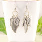 Statement Tibetan Silver Leaf Charm Earrings displayed on a tea cup.