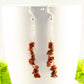 Long Silver Plated Chain and Red Jasper Chip Earrings displayed on a coffee mug.