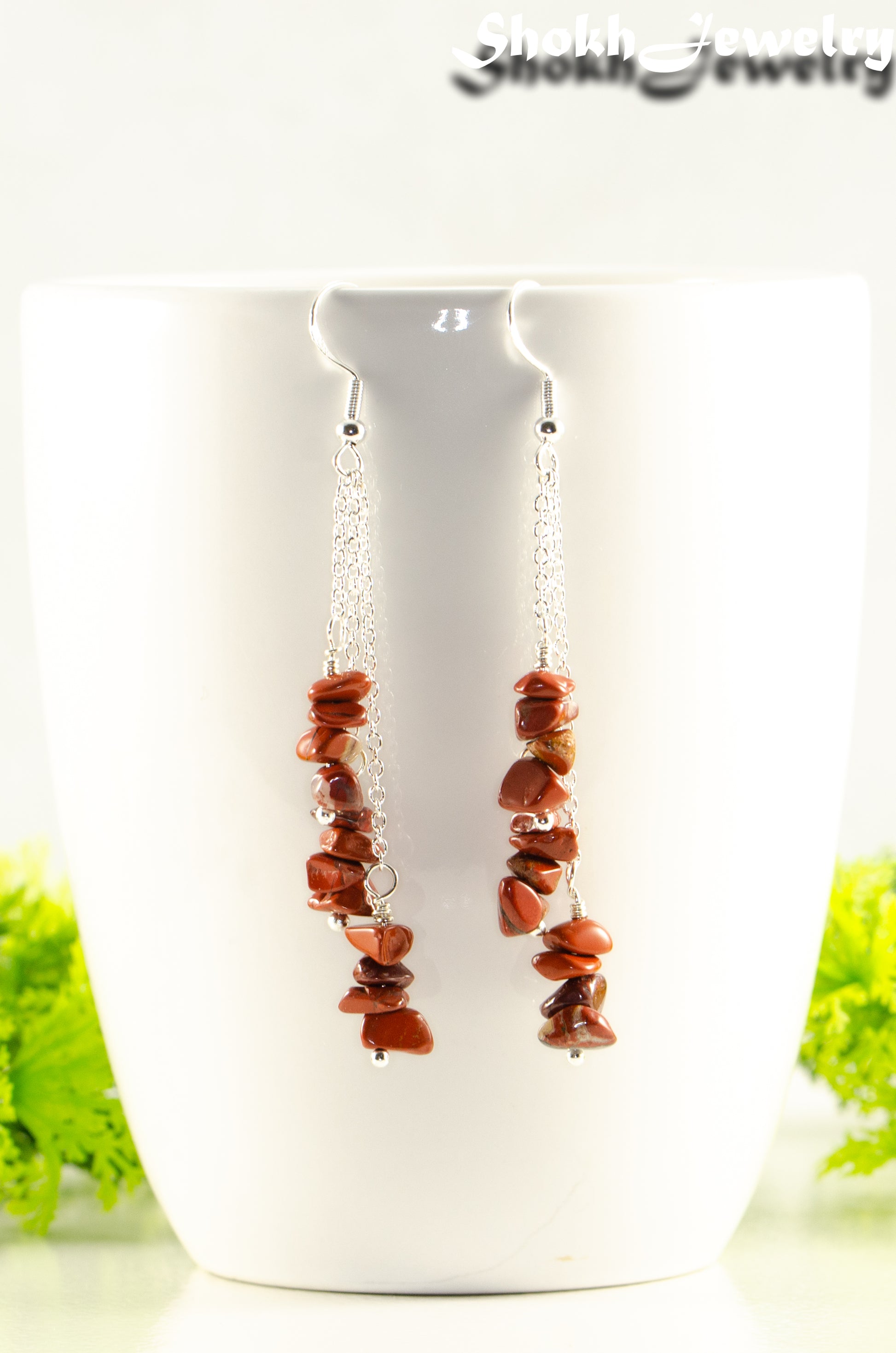 Long Silver Plated Chain and Red Jasper Chip Earrings displayed on a coffee mug.