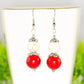 Red and White Howlite Dangle Earrings displayed on a tea cup.