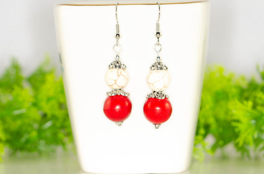 Red and White Howlite Dangle Earrings displayed on a tea cup.