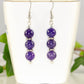 Natural Purple Dragon Vein Agate Beaded Bar Earrings displayed on a tea cup.