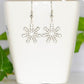 Christmas Snowflakes Charm Earrings displayed on a tea cup.