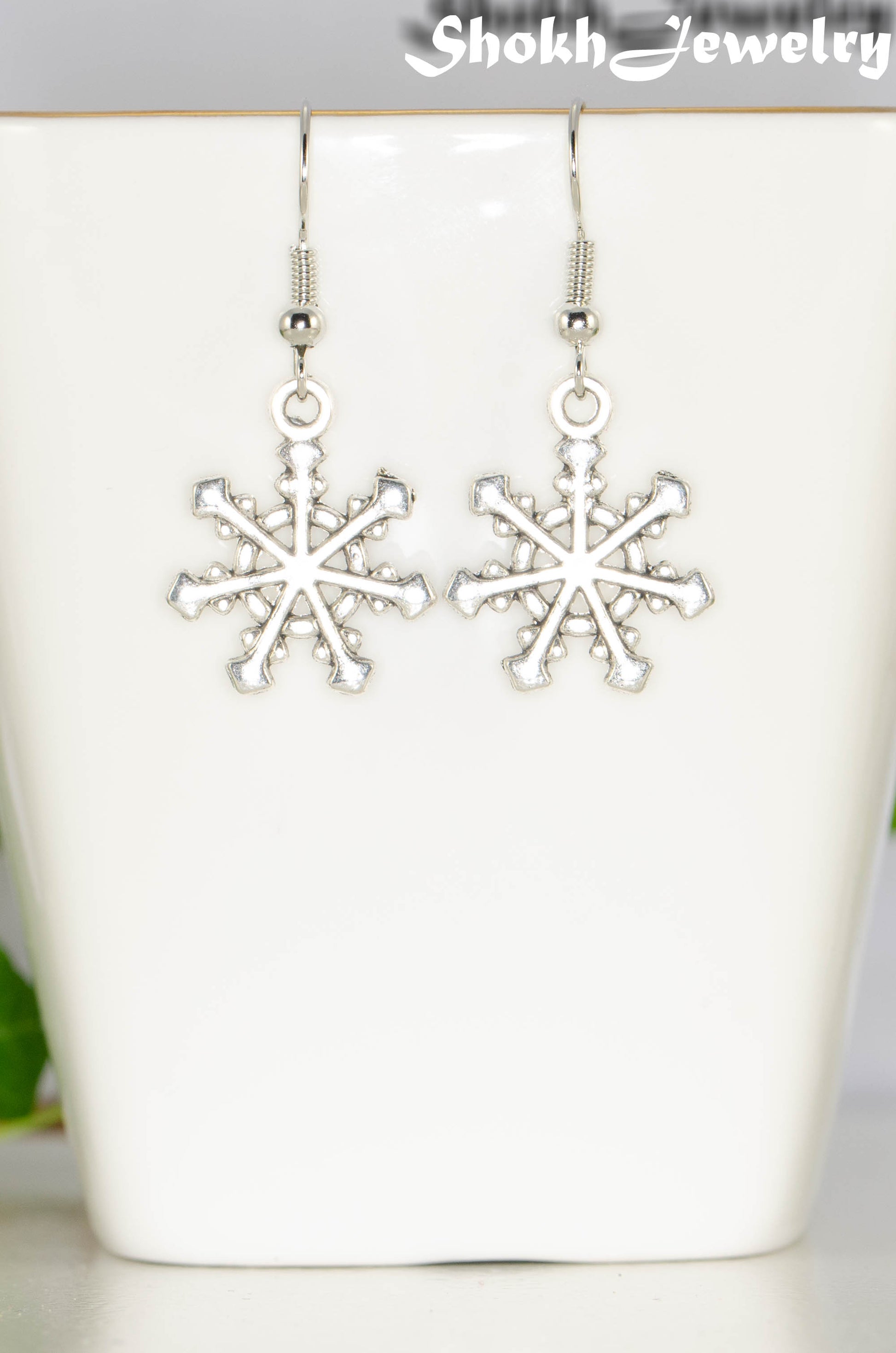 Close up of Christmas Snowflakes Charm Earrings.