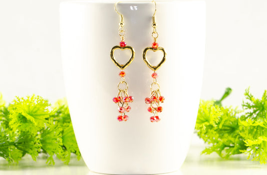 Gold Plated Heart and Red Crystal Cluster Earrings displayed on a coffee mug.