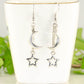 Crescent Moon and Hollow Star Earrings displayed on a tea cup.