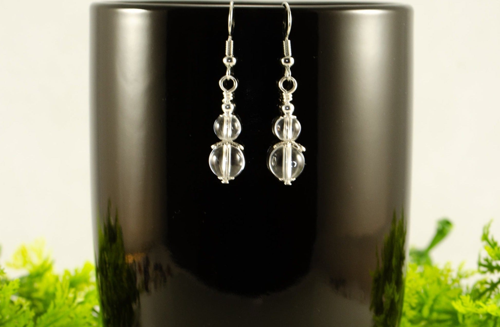 Small Clear Quartz Earrings displayed on a coffee mug.