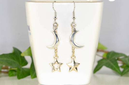 Crescent Moon and Mismatched Gold Star Earrings displayed on a tea cup.