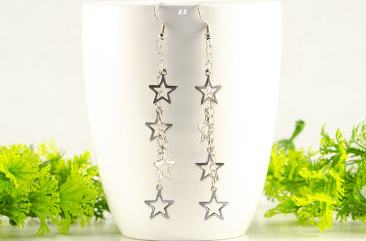 Stainless steel chain and 4 star earrings displayed on a coffee mug.