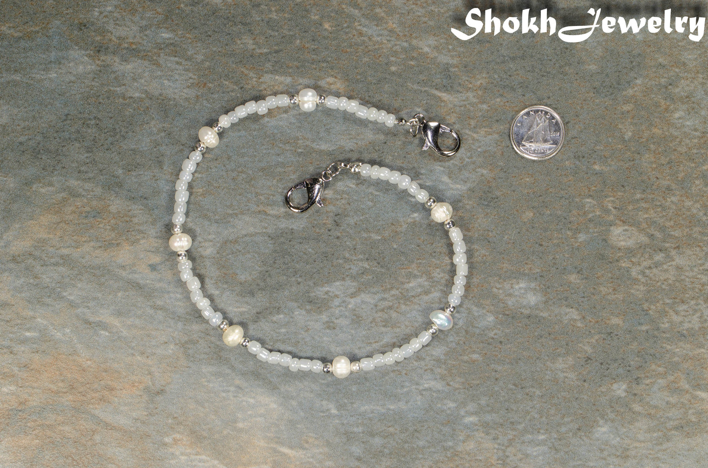 Freshwater Pearl and seed bead Eyeglass Chain beside a dime.