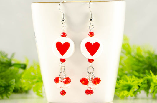 Statement Red Heart Ceramic Bead Earrings displayed on a tea cup.