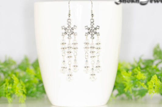 Clear Glass Crystal Chandelier and Snowflakes Earrings displayed on a coffee mug.