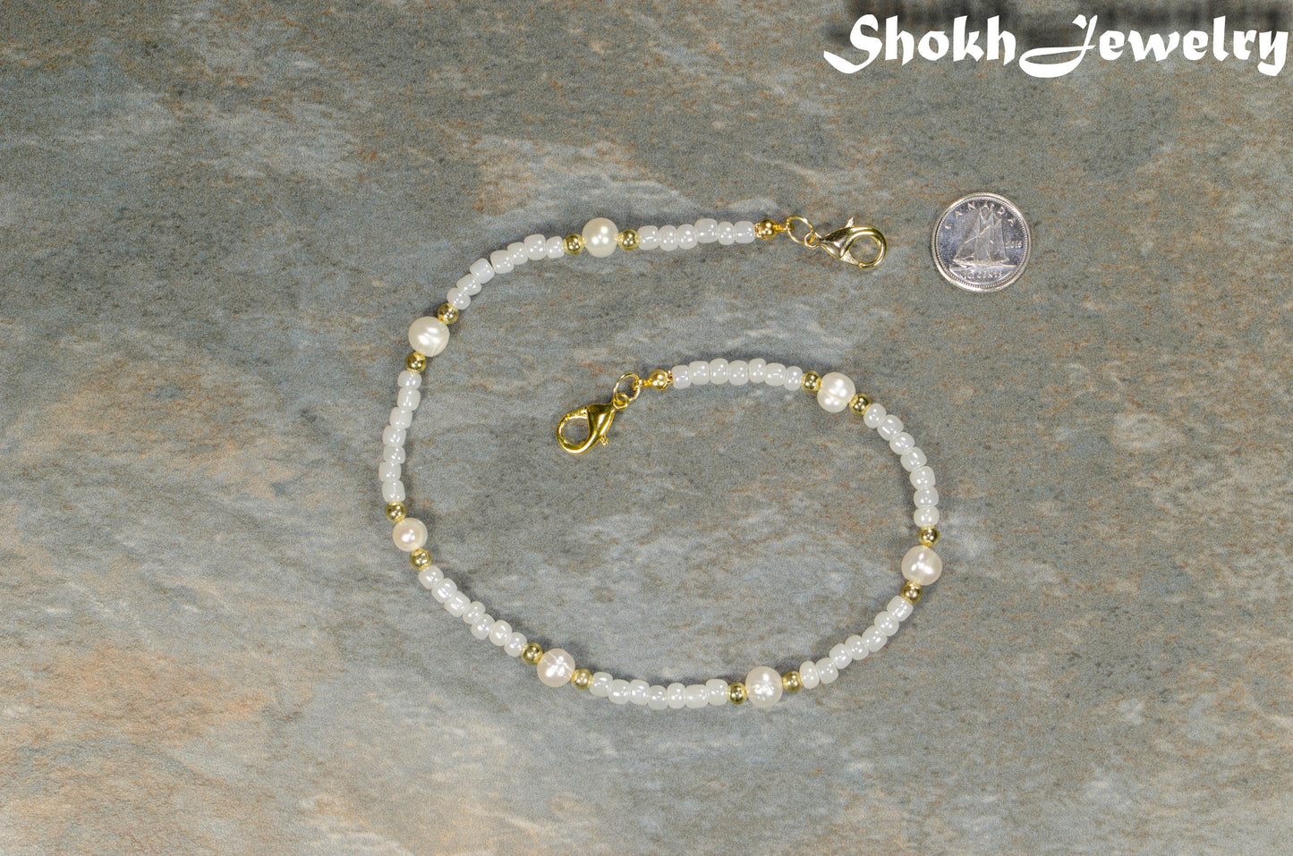 Freshwater Pearl and seed bead Eyeglass Chain beside a dime.