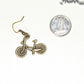 Antique Bronze Bicycle Charm Earrings beside a dime.