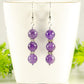 Natural Amethyst Beaded Bar Earrings displayed on a tea cup.