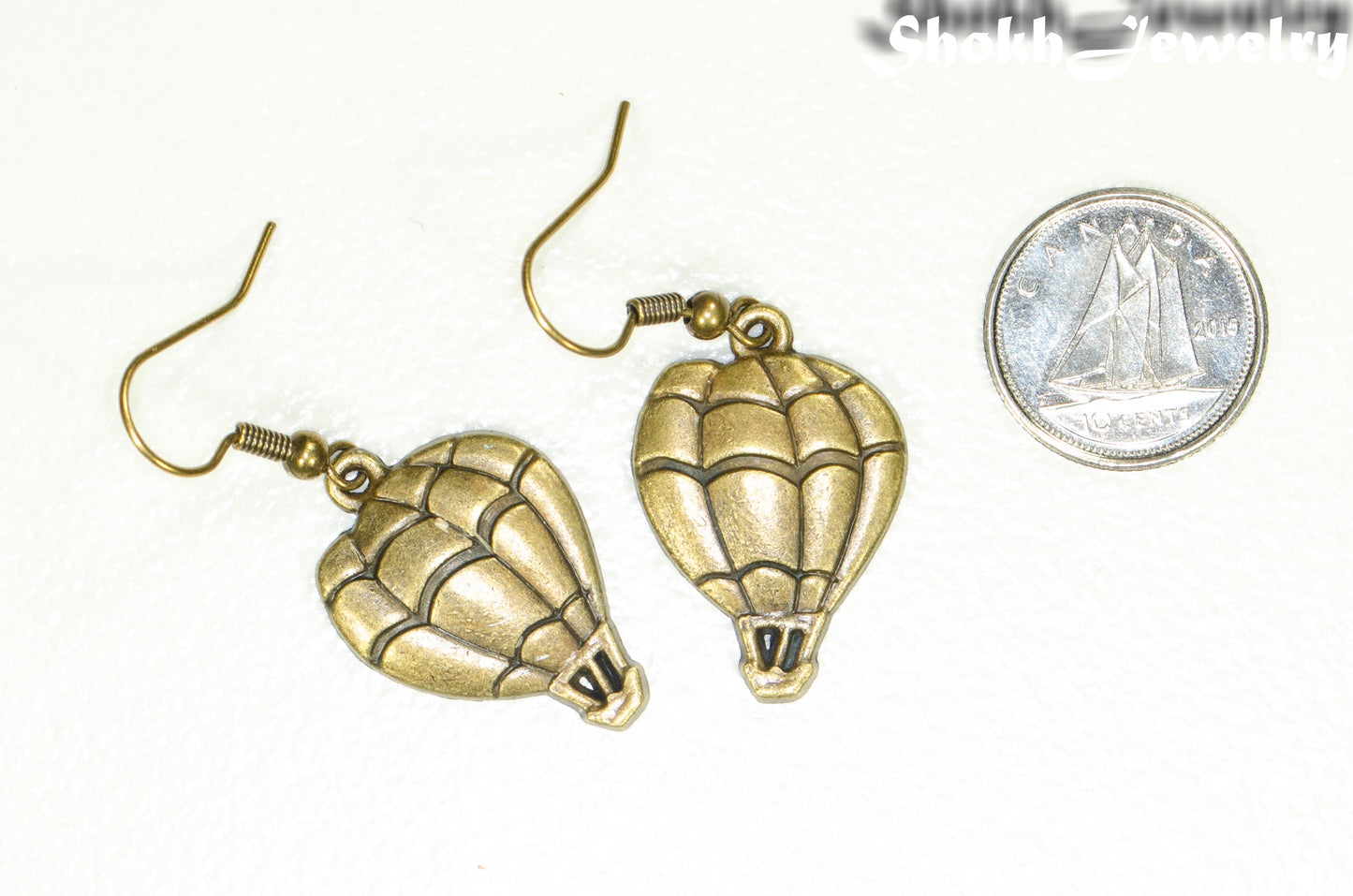 Antique Bronze Hot Air Balloon Charm Earrings beside a dime.
