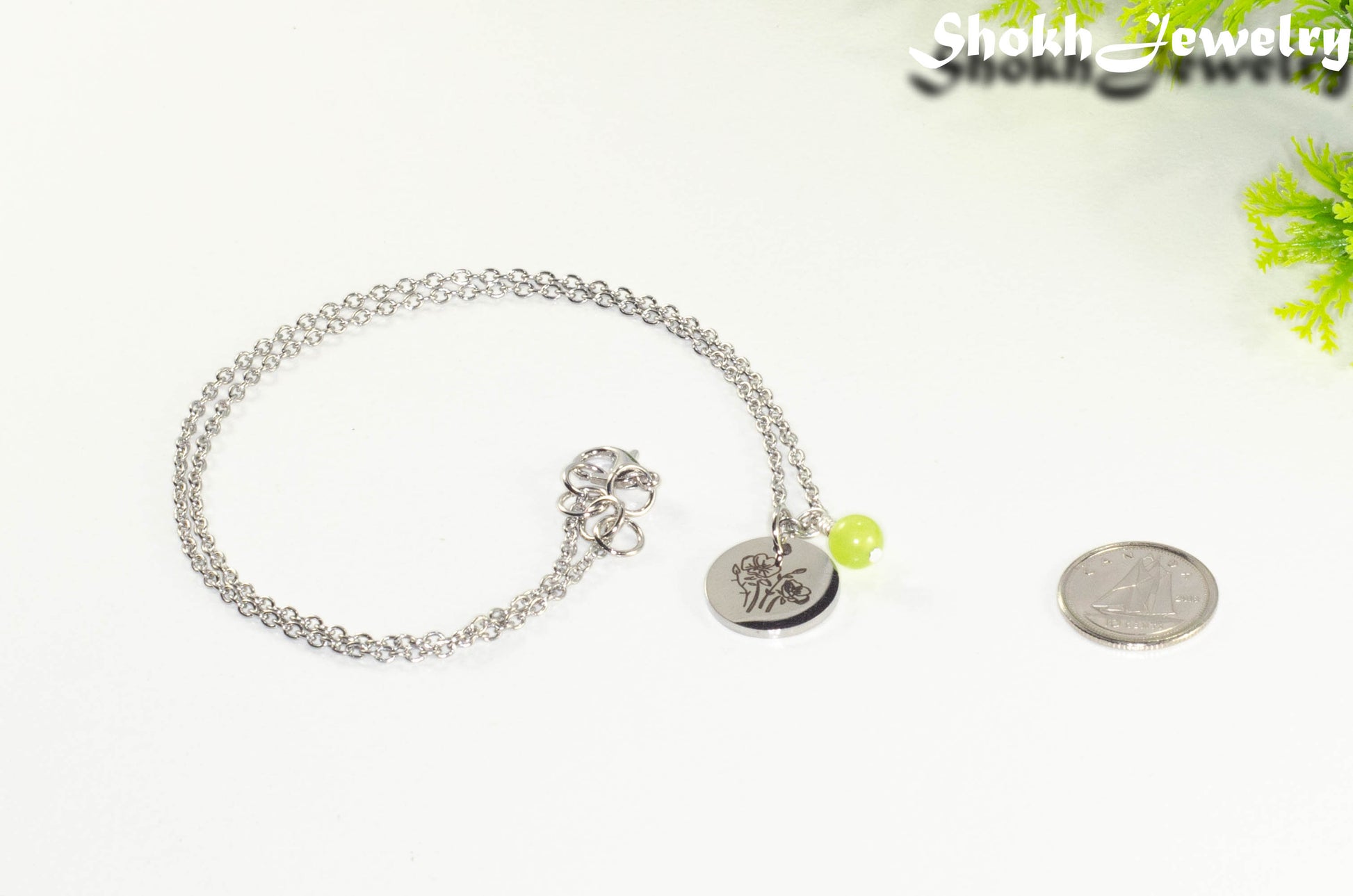 August Birth Flower Necklace with Peridot Birthstone Pendant beside a dime.