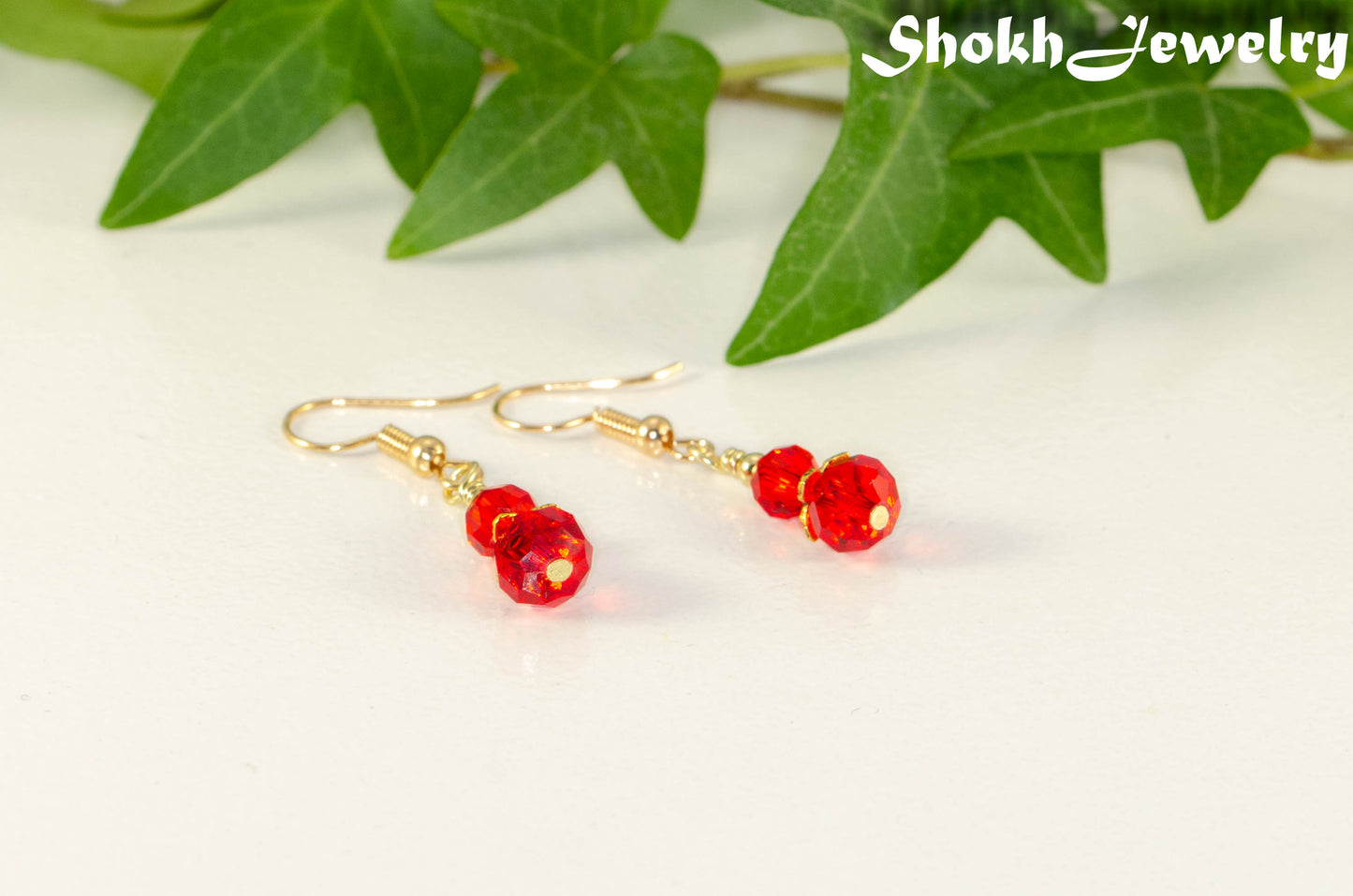 Small Red Glass Bead Dangle Earrings with gold tone ear wires.