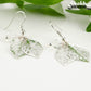 Close up of Filigree Silver Leaf Charm and Clear Glass Crystal Earrings.