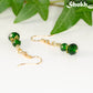 Close up of Small Dark Green Glass Bead Dangle Earrings.