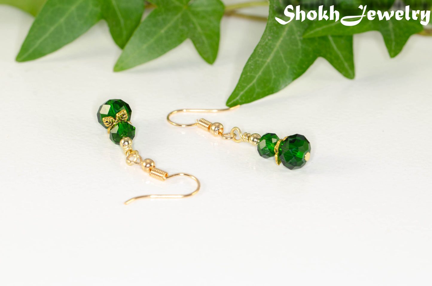 Close up of Small Dark Green Glass Bead Dangle Earrings.