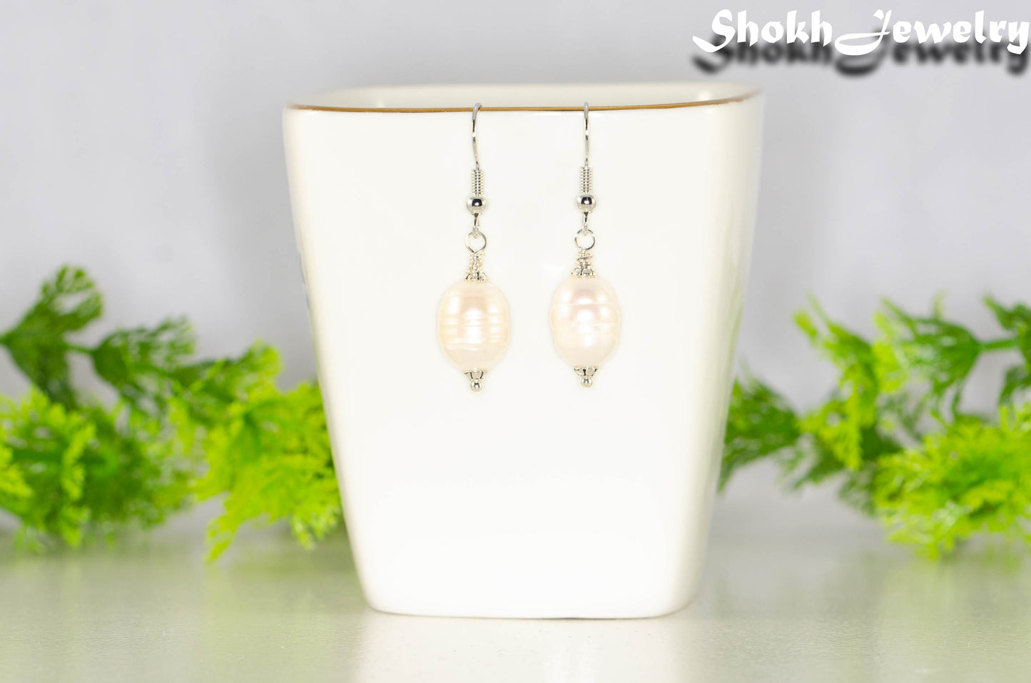 12mm Natural Freshwater Pearl Earrings displayed on a tea cup.