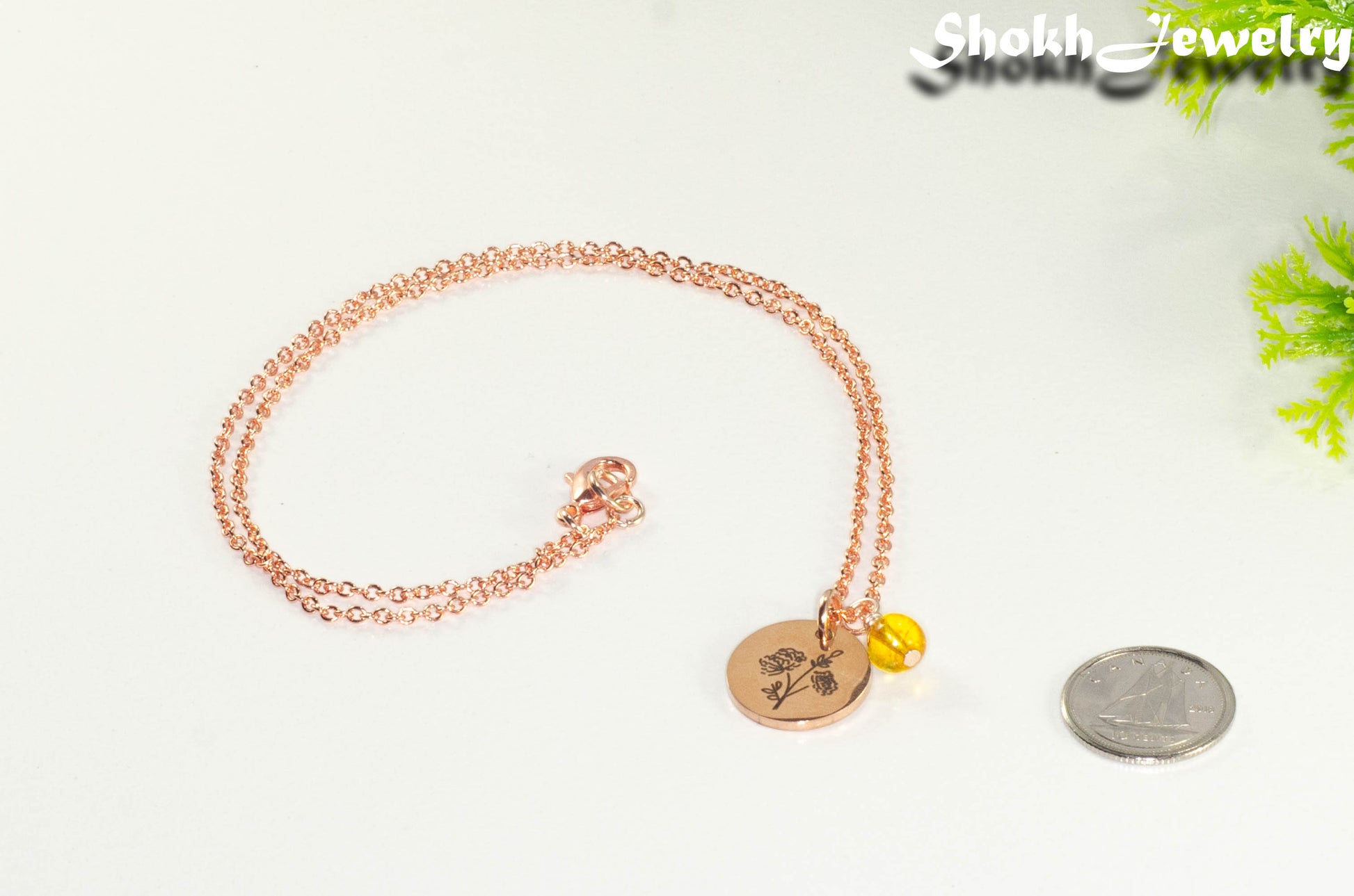 Rose Gold Plated November Birth Flower Necklace with Citrine Birthstone Pendant beside a dime.