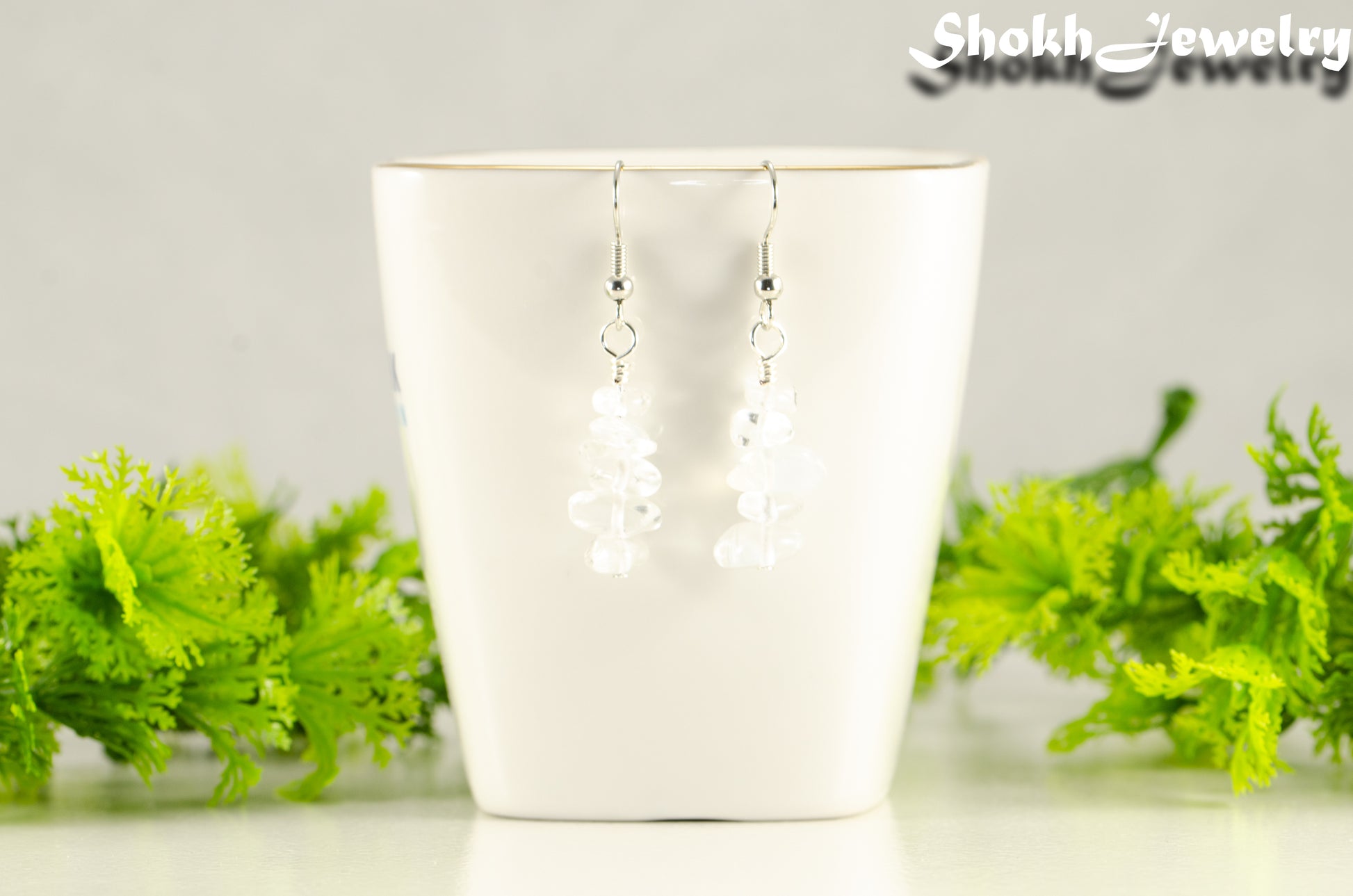Simple White Opal Crystal Chip Earrings displayed on a tea cup.
